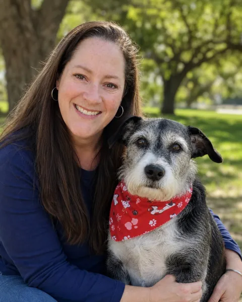 Kristen from Pawsitive Pet Care smiling with a senior dog outdoors